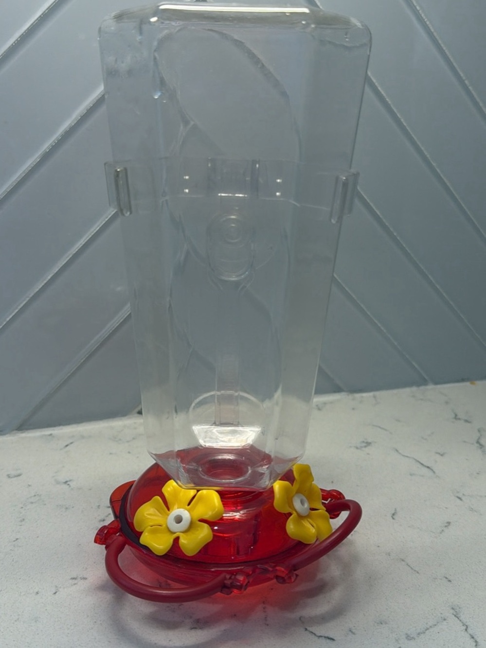 Clear Plastic Hummingbird Feeder with Red Base and Yellow Flowers